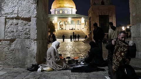 Palestinian Muslims break their fast during the Muslim holy month of Ramadan outside the Dome of Rock at the Al-Aqsa Mosque compound in the Old City of Jerusalem, Saturday, March 16, 2024.