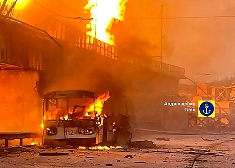 In this photo provided by Petro Andryuschenko, the adviser of the head of Mariupol city's administration, burning trolleybus is seen on the damp of hydroelectric power station after Russian attacks in Dnipro, Ukraine, Friday, March 22, 2024. Over 60 drones and almost 90 missiles of various types were fired that night, Ukrainian officials said.