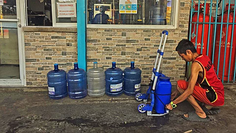 refilling water. A man ties up the plastic container on a handcart after refilling it at a water station on the corner of Junquera and Sanciangko Streets in Barangay Kamagayan, Cebu City on Thursday, April 4, 2024. Low water supply due to the El Niño phenomenon has affected some water stations in the city. /