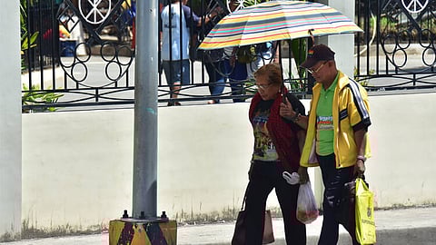 NOON TIME HEAT. An elderly couple brave the noontime heat along San Pedro Street.