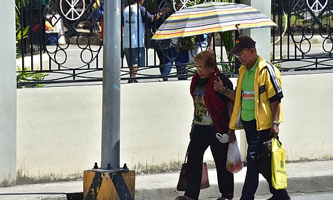 NOON TIME HEAT. An elderly couple brave the noontime heat along San Pedro Street.