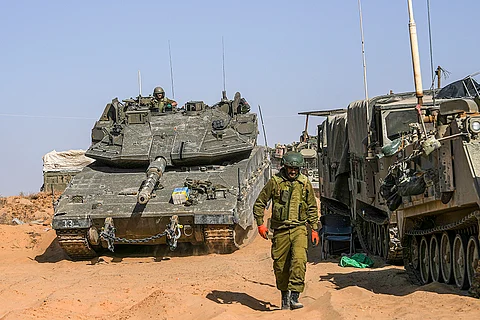 Israeli soldiers drive a tank at a staging ground near the border with the Gaza Strip, in southern Israel, Sunday, May 5, 2024.