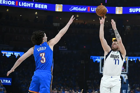 Dallas Mavericks guard Luka Doncic, right, shoots against Oklahoma City Thunder guard Josh Giddey during the first half in Game 2 of an NBA basketball second-round playoff series, Thursday May 9, 2024, in Oklahoma City.