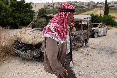 Fatahi Dawabsha, 82, walks past his family's vehicles that were torched during an attack by Israel settlers last month, in the West Bank village of Duma, Tuesday, April 30, 2024.