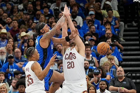 Orlando Magic forward Paolo Banchero loses the ball as he gets caught between Cleveland Cavaliers forward Isaac Okoro, left, and forward Georges Niang (20) during the first half of Game 6 of an NBA basketball first-round playoff series, Friday, May 3, 2024, in Orlando, Fla.
