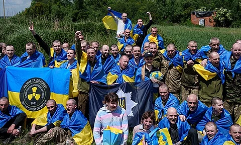 Ukrainian servicemen shout "Glory to Ukraine" after returning from captivity during POWs exchange in Sumy region, Ukraine, Friday, May 31, 2024. Ukraine returned 75 prisoners, including four civilians, in the latest exchange of POWs with Russia. It's the fourth prisoner swap this year, and 52nd since Russia invaded Ukraine. In all, 3 210 Ukrainian servicemen and civilians were returned since the outbreak of the war.