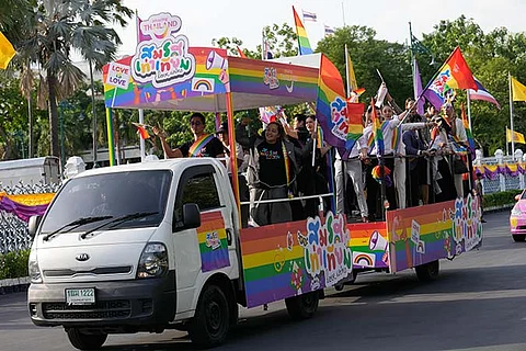 Participants wave flags celebrating equality in marriage at government house in Bangkok, Thailand, Tuesday, June 18, 2024. Thailand's Senate voted overwhelmingly on Tuesday to approve a marriage equality bill, clearing the last legislative hurdle for the country to become the first in Southeast Asia to enact such a law.