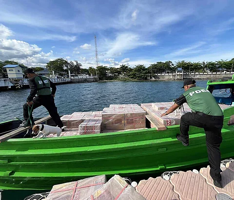 ZAMBOANGA. A K-9 unit of the Philippine Drug Enforcement Agency checks the master cases of cigarettes to ensure no drug substance were mixed with the P10.2 million smuggled cigarettes the Naval Task Force-61 personnel seized off Sulu on Friday, May 31.