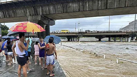 MANILA. Residents watch the Marikina river as it floods from monsoon rains worsened by offshore typhoon Gaemi on Wednesday, July 24, 2024, near Manila, Philippines.