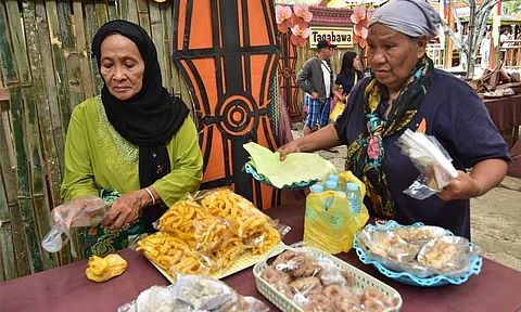 FOOD FEST. In this 2018 file photo, Maguindanaoan women prepare their tribe's delicacies at the Pananam Food Hall inside the Kadayawan Village at Magsaysay Park in Davao City where the 11 tribe's food is available for sale.