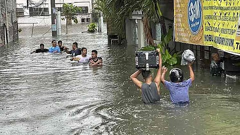 MANILA. People wade through a flooded street following monsoon rains worsened by offshore Typhoon Carina on Wednesday, July 24, 2024, in Manila, Philippines.