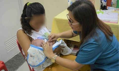 YOUNG MOM. A health worker attends to a young mother and her baby in this undated photo.