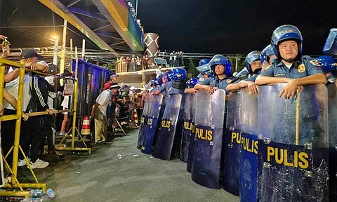 Police forces barricaded the Kingdom of Jesus Christ (KOJC) compound as hundreds of members hold a protest outside on Sunday evening, August 25, nearly two days after the Philippine National Police entered the compound to search for Pastor Apollo Quiboloy.
