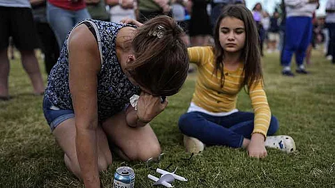 USA. Brandy Rickaba and her daughter Emilie pray during a candlelight vigil for the slain students and teachers at Apalachee High School, Wednesday, September 4, 2024, in Winder, Georgia.