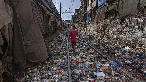 INDIA. A man walks on a railway track littered with plastic and other waste materials on Earth Day in Mumbai, India, April 22, 2024.