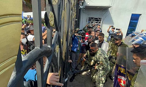 STANDOFF. Police personnel are seen forcing entry at the Emerald Gate of the Kingdom of Jesus Christ (KOJC) compound, despite another gate being open for access. The police operation, aimed at serving an arrest warrant against Pastor Apollo C. Quiboloy and four others, reached Day 16, following the Senate public hearing on September 7, 2024, at the Sangguniang Panlungsod in Davao City.