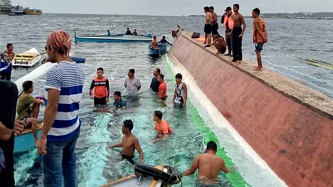ZAMBOANGA. Personnel of the Philippine Coast Guard (PCG) rescue 32 people after a motorboat capsizes in the vicinity 500 yards west of the port of Siasi, Sulu on Saturday, September 14, 2024. A photo handout shows the ill-fated motorboat (right) was towed to the shore upside down. (SunStar Zamboanga)