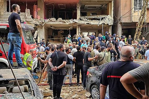 Residents look on as rescuers arrive at the scene of an Israeli missile strike in the southern suburbs of Beirut, Friday, Sept. 20, 2024.