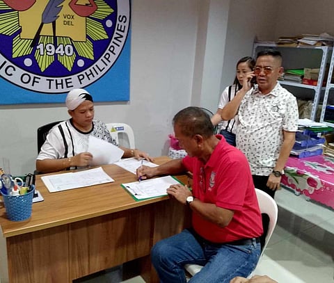 ZAMBOANGA. Mayor Roderick Furigay (seated) of Lamitan City, Basilan province, accompanied by his legal counsel Quirino Esguerra, Jr. (standing in glasses), files his certificate of candidacy on Saturday, October 5, under the Partido Federal ng Pilipinas at the office of the Commission on Elections in that city.