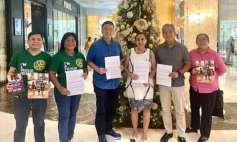 Chi Laigo Vallido, Executive Director of PNGOC (center, in a white dress), and Atty. Eduardo Escano, Founding President of WALK Inc. (center, in a blue shirt), display the signed Memorandum of Understanding.