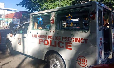 In this file photo, a mobile police car parked in front of the San Pedro police station was spotted to have Christmas decorations all over but with the tarpaulin of wanted individuals too.