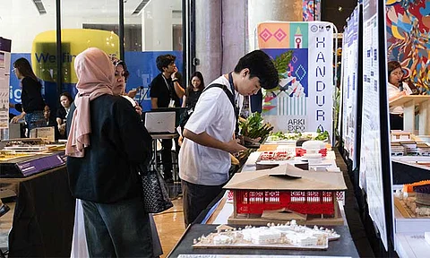 A student examines a scale model displayed at the HANDURAW Arki Expo 2025.