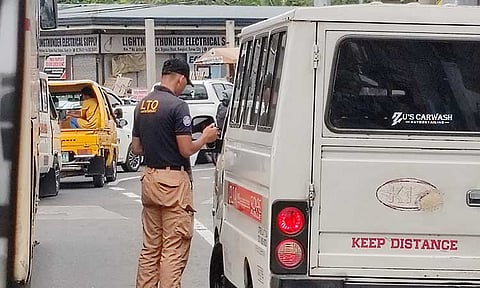 CRACKDOWN. An enforcer from the Land Transportation Office issues a ticket to a vehicle along Ulas, Davao City. In March, the LTO apprehended 18,882 motor vehicles nationwide as part of its ongoing campaign against unregistered or 'colorum' vehicles.