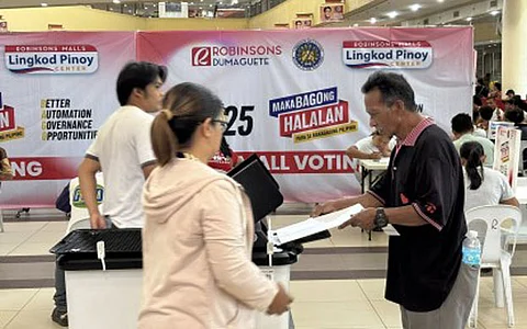 VOTING PROCESS. A man feeds his ballot into the automated counting machine at a clustered voting precinct inside Robinsons mall in Dumaguete City, Negros Oriental on May 12, 2025. The Diocesan Electoral Board of the Diocese of Dumaguete has acknowledged and affirmed the Commission on Elections' explanation that there was no discrepancy in the counting of ballots at a precinct in the provincial capital.