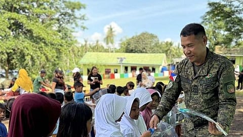 ZAMBOANGA. Lieutenant Colonel Dante Mantes, 101st Infantry Battalion commander, distributes school supplies to young learners during a feeding program Friday, July 11, in Likubong Elementary School, Niangkaan village, Omar, Sulu. He encouraged the young learners to focus on their studies.