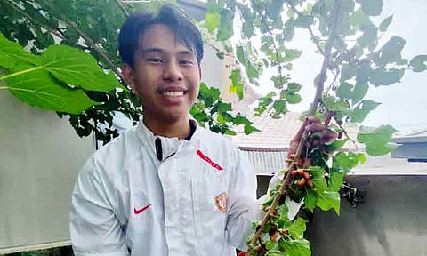 Dabawenyo teen Jireh Steve Uy proudly holds a branch from his thriving mulberry tree, a testament to how his backyard hobby has grown into Hiraya’s Tea Garden, a budding agribusiness that inspires fellow youth to try farming.