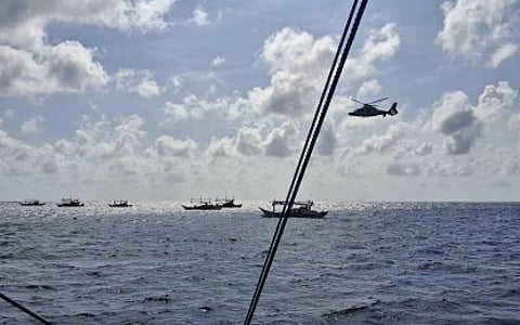 PROTECTING WPS. A Chinese People's Liberation Army Navy helicopter chases after several Filipino fishing boats at the Rozul Reef in the West Philippine Sea (WPS) on Nov. 27, 2024. The Department of National Defense on Wednesday (Sept. 17, 2025) said more military bases and assets are needed to secure the WPS amid Chinese aggression. (Photo courtesy of Philippine Coast Guard)