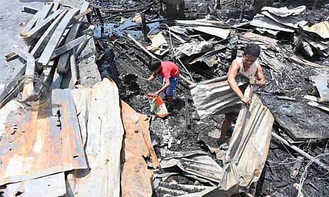 PICKING UP THE PIECES. After a massive fire razed some 400 homes in Barangay 21-C, Piapi Boulevard, Davao City, Thursday afternoon, October 2, 2025, residents return to the blackened ground where their houses once stood. With nothing left but ashes, families dig through the rubble—scraping for iron sheets, wood, and anything they can use to rebuild. They search for fragments of their former lives, carrying what little they can salvage. What once was home is now dust, but the will to start over burns stronger than the fire that destroyed everything.