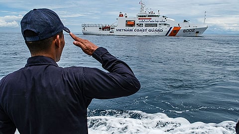 A Philippine Coast Guard (PCG) personnel salutes the Vietnam Coast Guard (VCG) patrol vessel csb 8002 as it sets sail back to Vietnam on Friday, Oct. 10, 2025.