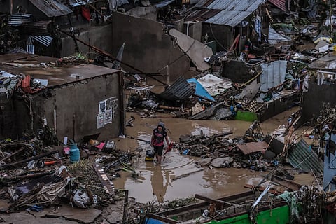 SOAKED. A resident in Barangay San Isidro, Talisay City, attempts to salvage what remained after Typhoon Tino caused massive flooding on November 4, 2025. The typhoon's heavy rains made the Mananga River overflow and damaged and destroyed hundreds of houses in San Isidro. / JUAN CARLO DE VELA