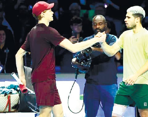 MATCH-END HANDSHAKE. Jannik Sinner (left) and Carlos Alcaraz firmly clasp hands after their ATP Finals match, with Alcaraz’s taped thigh visible as the world’s top two players ackowledge another hard-fought chapter in their growing rivalry. /