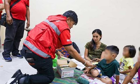 RELIEF. Department of Social Welfare and Development in Bicol (DSWD-5) Regional Director Norman Laurio gives biscuits to children in an evacuation center in Camalig, Albay on Tuesday night (Jan. 6, 2026). More than 160 ready-to-eat food packs were distributed to Mayon-affected families. (Photo courtesy of DSWD-5)