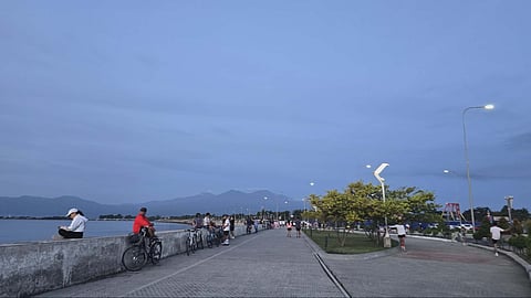 Cyclists take a rest by the sea wall of the Davao City Coastal Road.