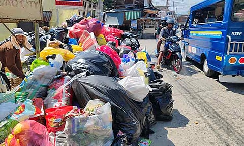 GARBAGE COLLECTION. Personnel from the Davao City Environment and Natural Resources Office (Cenro) work under the heat of the sun to collect sacks of accumulated garbage at Phase 5 in El Rio Vista Village, Bacaca, Davao City, on Sunday noon, January 18, 2026. Waste management remains a challenge in the city, where daily garbage collection has surged to around 700 to 800 tons, stretching existing collection and landfill capacity and prompting efforts to expand facilities and improve segregation practices. Delays in collection in some barangays have also led to foul odors and community complaints, highlighting the urgency of stronger enforcement and public cooperation in proper waste disposal.