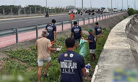 Environmental groups and volunteers conduct coastal cleanup along Davao City Coastal Road, collecting 12 sacks of trash during a clean-up in Matina Aplaya.