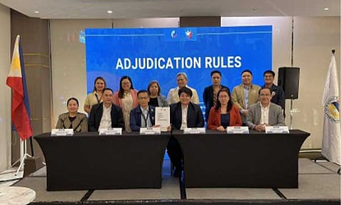 NEW RULES. Migrant Workers Secretary Hans Leo Cacdac (3rd from left, seated), together with Overseas Workers Welfare Administration chief Patricia Yvonne Caunan, and other DMW officials, show the newly signed Rules of Procedure for the Adjudication of Cases in Quezon City Thursday (Feb. 12, 2026). The new rules aim to speed up justice for overseas Filipino workers (OFWs) by streamlining procedures and decentralizing hearings to regional offices. (Photo courtesy of DMW)