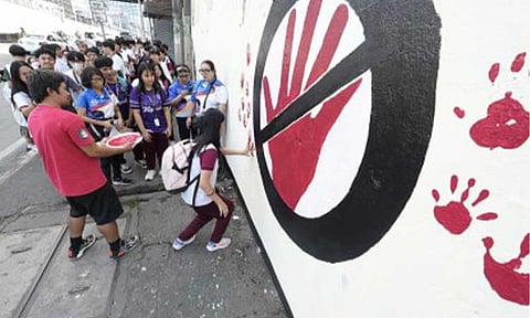 ANTI-BULLYING MURAL. A student places a red handprint on a wall beside Ramon Magsaysay High School along EDSA in Cubao, Quezon City on (March 13, 2026), part of a three-day anti-bullying mural project. Senators on Monday (March 16, 2026) pushed for stronger anti-bullying policies in schools as a Senate panel reviewed existing safeguards amid persistent reports of bullying incidents involving Filipino students. (PNA photo by Robert Oswald P. Alfiler)