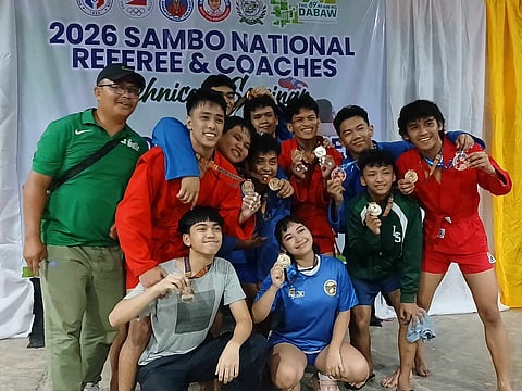 The De La Salle Sambo Team members and coach Samson Bernales celebrate their wins in the recently concluded 2026 Araw ng Dabaw Sambo National Open Championships.