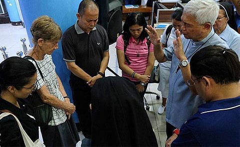 MANILA. In this photo posted on the CBCP website, Manila Auxiliary Bishop Broderick Pabillo (2nd from right) prays over Sister Patricia Fox (2nd from left) at the Bureau of Immigration office, where she is detained.
