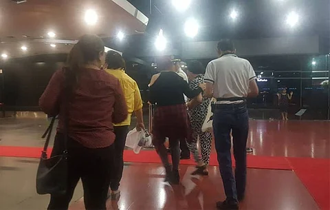 CEBU. Thelma Chiong, mother of the late Jacqueline and Marijoy Chiong, is escorted out of the theater. She was emotional when she saw the brutal rape scenes of the movie "Jacqueline Comes Home." (SunStar)