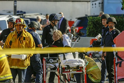 LOS ANGELES. An unidentified woman is helped by paramedics at a triage area after a gunman held dozens of people hostage inside a Trader Joe's store in Los Angeles Saturday, July 21, 2018. Police believe a man involved in a standoff at the Los Angeles supermarket shot his grandmother and girlfriend and then fired at officers during a pursuit before he crashed into a utility pole outside the supermarket and ran inside the store. Hours after he took hostages in the store, the suspect surrendered. (AP)