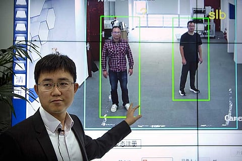 In this Oct. 31, 2018, photo, Huang Yongzhen, CEO of Watrix, demonstrates the use of his firm's gait recognition software at his company's offices in Beijing. A Chinese technology startup hopes to begin selling software that recognizes people by their body shape and how they walk, enabling identification when faces are hidden from cameras. Already used by police on the streets of Beijing and Shanghai, "gait recognition" is part of a major push to develop artificial-intelligence and data-driven surveillance across China, raising concern about how far the technology will go. (AP)