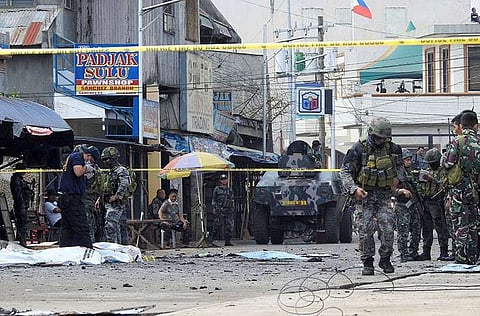 SULU. In this January 27, 2019, file photo, police investigators and soldiers attend the scene after two bombs exploded outside a Roman Catholic cathedral in Jolo, Sulu. (AP)