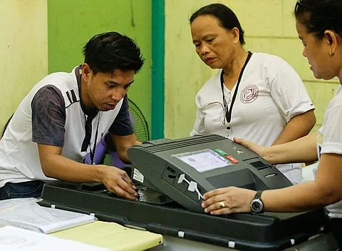 MANILA. Election workers try to fix a jammed ballot inside a counting machine at a polling center in the Manuel L. Quezon elementary school in Manila, Monday, May 13, 2019.