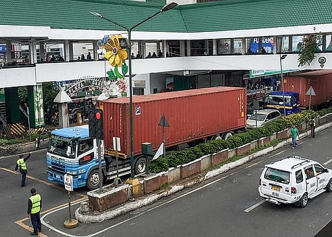 BAGUIO. Traffic enforcers stop three cargo trucks along Harrison Road on Sunday, July 14, for violating the truck ban at the Central Business District from 6 a.m. to 9 p.m. Baguio City is currently looking ways to help improve the traffic condition with the help of experts from MMDA. (Photo by Jean Nicole Cortes)