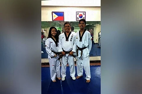 CAGAYAN DE ORO. Melissa Maxine and Kyle George flank their father/trainer George Arsenal after a previous training session at a family-run taekwondo gym in Cagayan de Oro. (Contributed Photo)